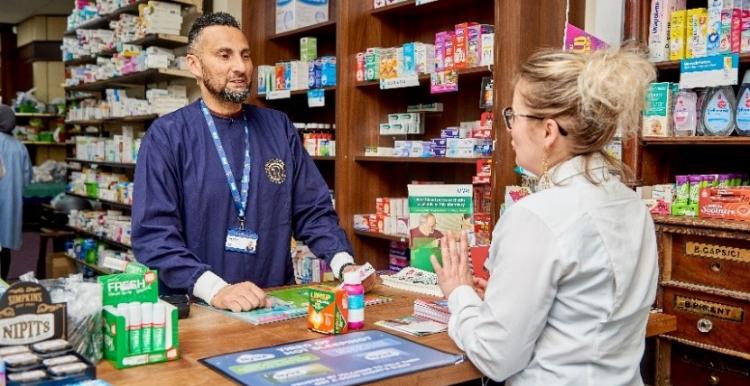 A photograph of a man and a woman inside a pharmacy