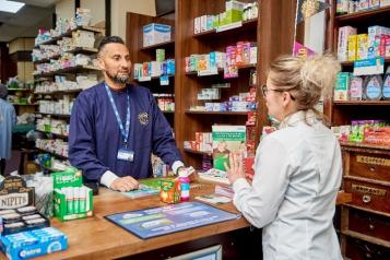 A photograph of a man and a woman inside a pharmacy